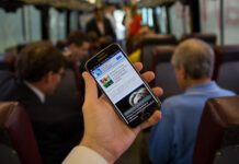 Here’s How to Get Free Wifi on Brighton’s Buses Person Using Phone on Bus